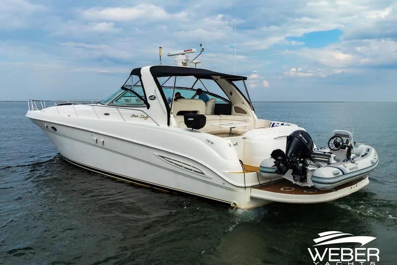 Slide: The Image of 2000 Sea Ray Sundancer 460 yacht cruising on open water under a cloudy sky. - 34