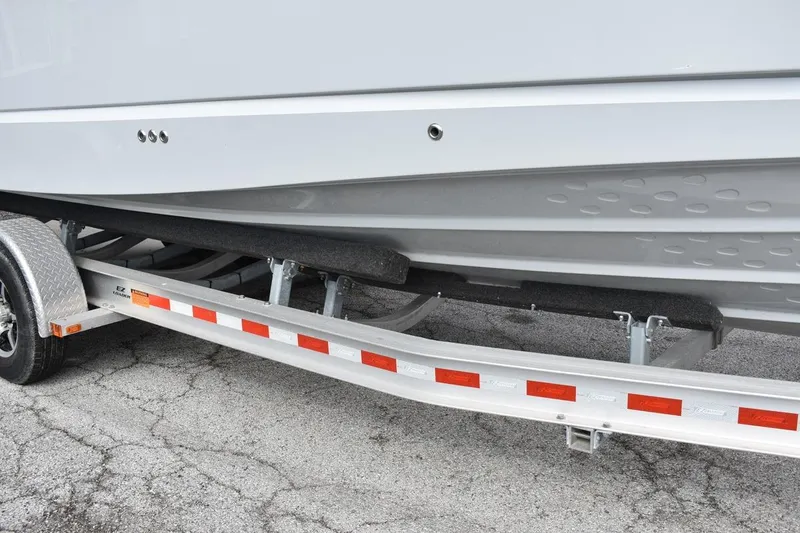 Slide: The Image of Trailer carrying a 2021 Ranger Tugs R-27 boat, showcasing hull and trailer details. - 15