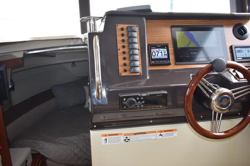 Slide: The Image of 2021 Ranger Tugs R-27 helm with navigation displays and cozy cabin interior. - 19