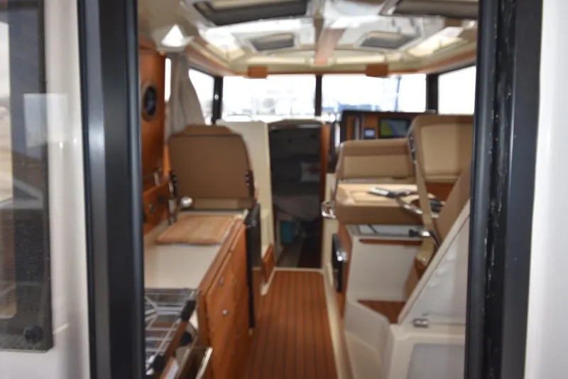 Slide: The Image of Interior view of 2021 Ranger Tugs R-27 boat, featuring wood accents and seating. - 21