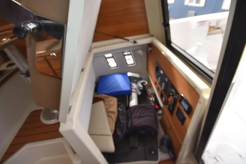 Slide: The Image of Interior view of 2021 Ranger Tugs R-27 cabin with control panel and storage area. - 22