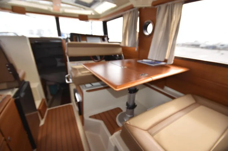 Slide: The Image of Interior of 2021 Ranger Tugs R-27 boat with wooden table and seating area. - 24