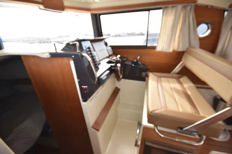 Slide: The Image of Interior of 2021 Ranger Tugs R-27 boat with helm and seating area. - 28