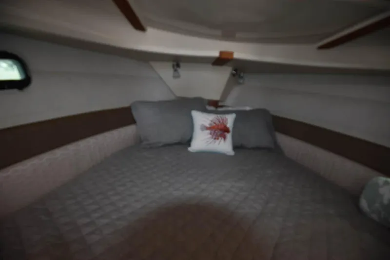 Slide: The Image of Cozy cabin interior of 2021 Ranger Tugs R-27 with plush bedding and decorative pillow. - 33