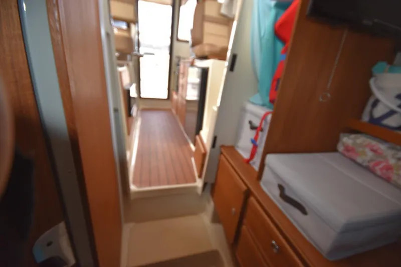 Slide: The Image of Interior view of 2021 Ranger Tugs R-27 boat, featuring wooden cabinetry and compact layout. - 35