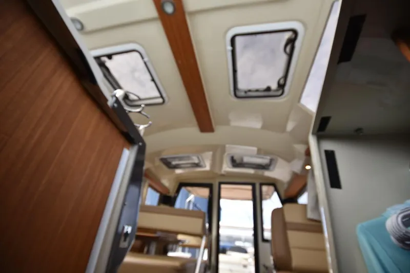 Slide: The Image of Interior view of 2021 Ranger Tugs R-27 boat, featuring skylights and seating area. - 36