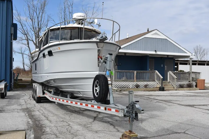 Slide: The Image of 2021 Ranger Tugs R-27 boat on trailer, parked near a building. - 4
