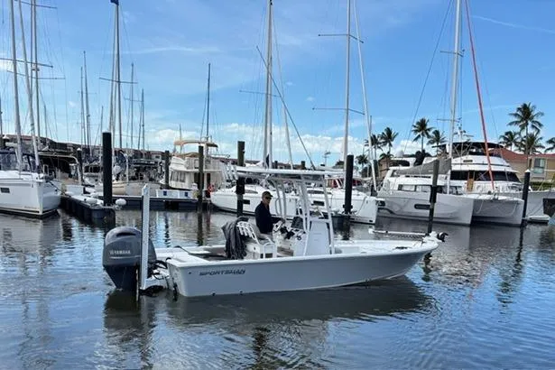 Slide: The Image of 2022 Sportsman Masters 227 Bay Boat docked in a marina with sailboats. - 12
