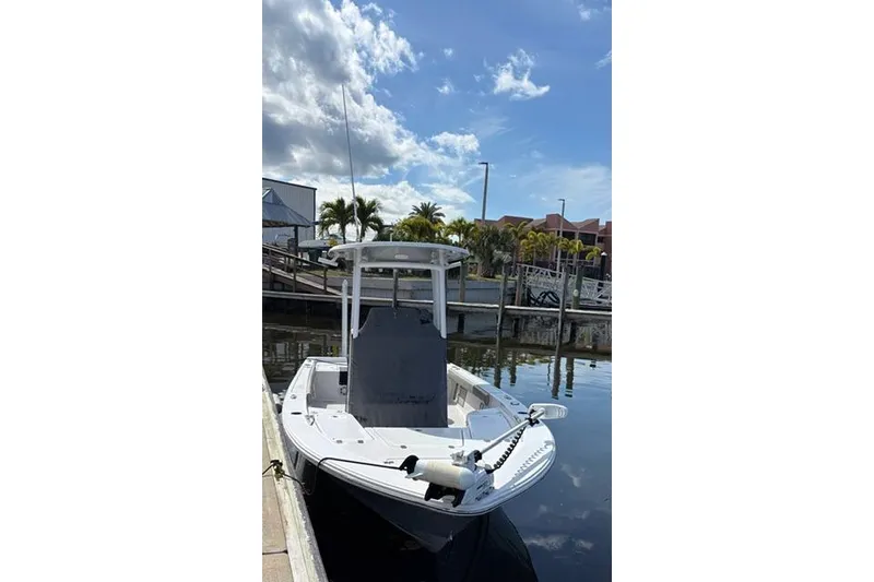 Slide: The Image of 2022 Sportsman Masters 227 Bay Boat docked under a sunny sky. - 13