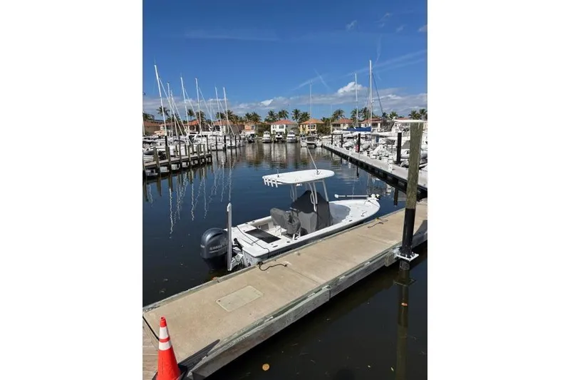 Slide: The Image of 2022 Sportsman Masters 227 Bay Boat docked at a marina under clear blue skies. - 3
