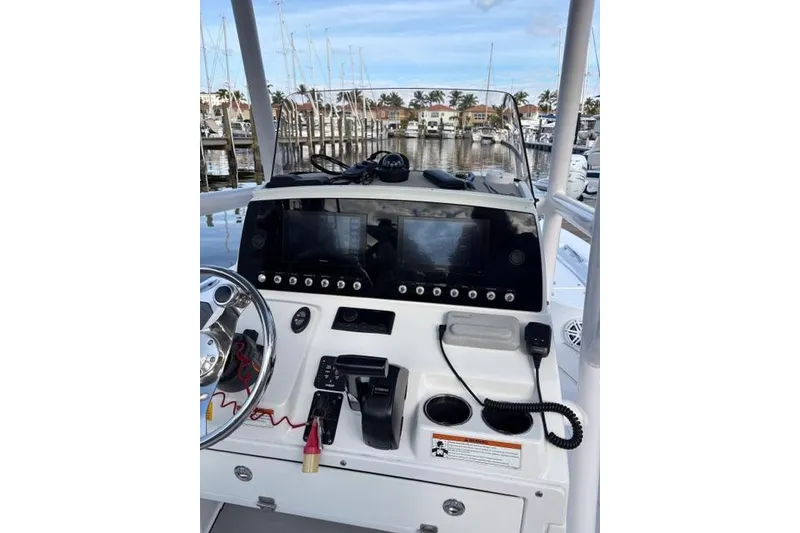 Slide: The Image of 2022 Sportsman Masters 227 Bay Boat dashboard with dual screens and controls at marina. - 7