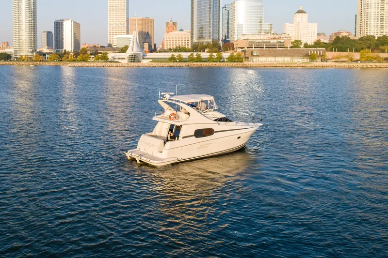 Slide: The Image of 2003 Silverton 410 Sport Bridge yacht cruising near city skyline. - 10