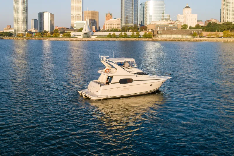 Slide: The Image of 2003 Silverton 410 Sport Bridge yacht cruising near city skyline. - 11