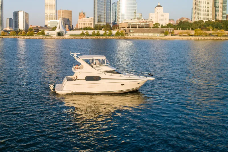 Slide: The Image of 2003 Silverton 410 Sport Bridge yacht on urban waterfront, city skyline in background. - 13