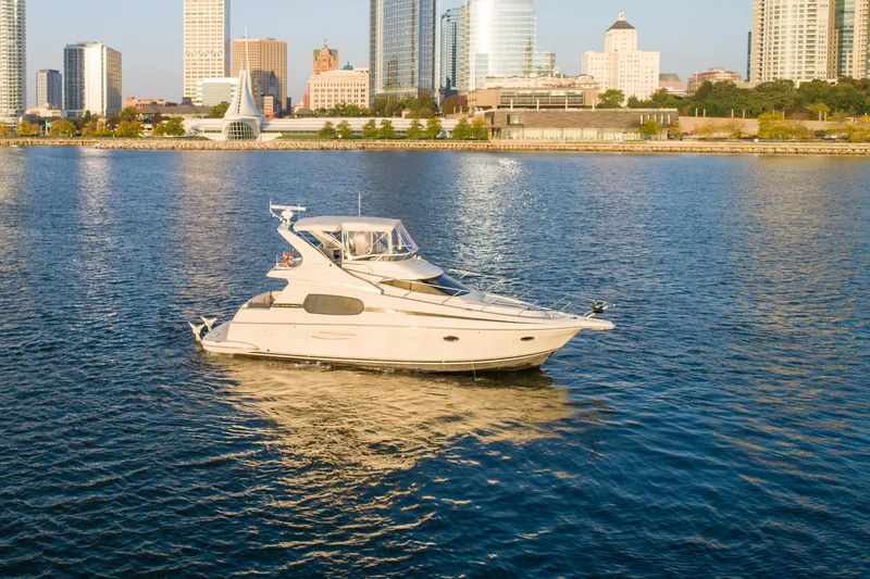 Slide: The Image of 2003 Silverton 410 Sport Bridge yacht cruising near city skyline. - 15