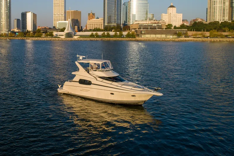 Slide: The Image of 2003 Silverton 410 Sport Bridge yacht on urban waterfront with city skyline. - 17