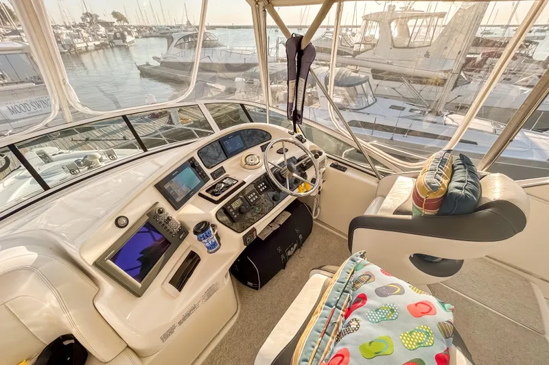Slide: The Image of 2003 Silverton 410 Sport Bridge yacht cockpit with modern navigation equipment and marina view. - 26