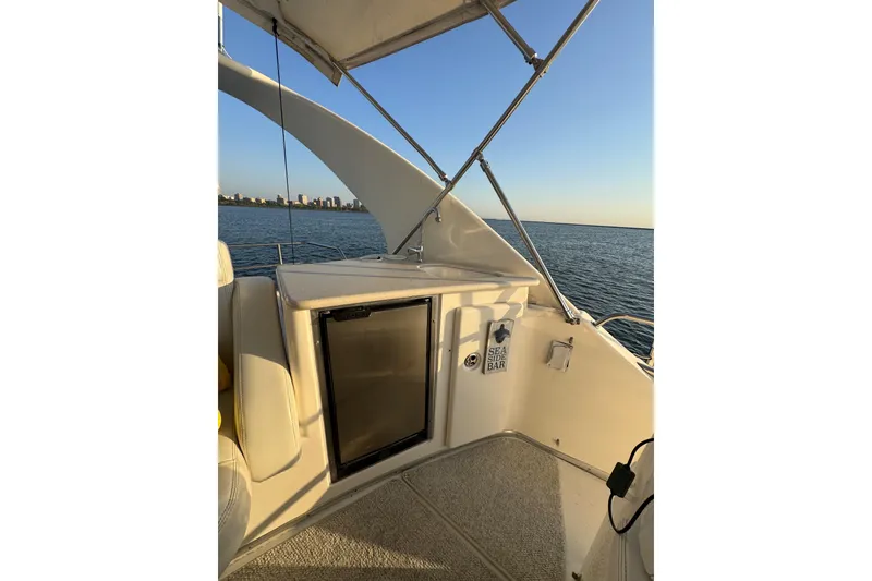 Slide: The Image of 2003 Silverton 410 Sport Bridge yacht interior with mini fridge and ocean view. - 34