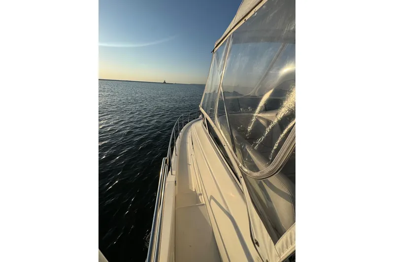 Slide: The Image of 2003 Silverton 410 Sport Bridge yacht cruising on calm waters at sunset. - 35