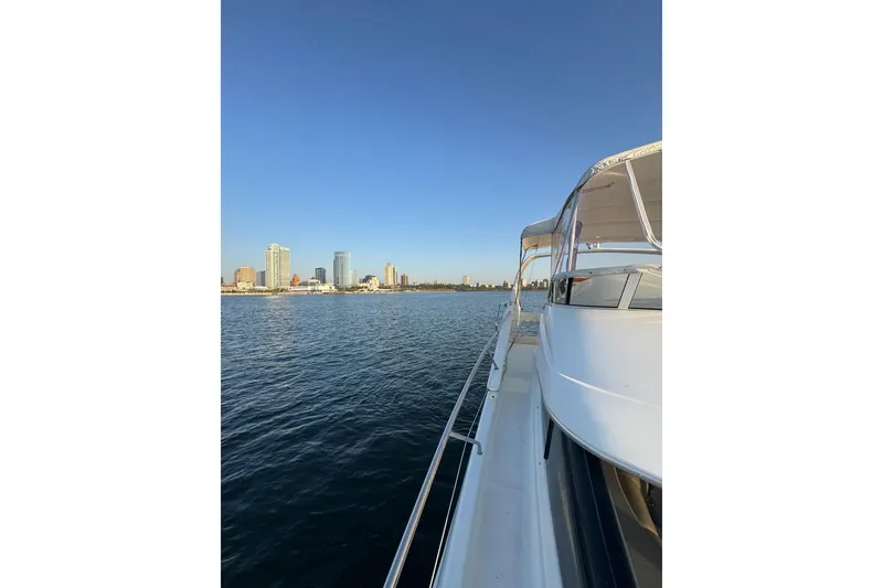 Slide: The Image of 2003 Silverton 410 Sport Bridge yacht cruising near city skyline on calm water. - 37