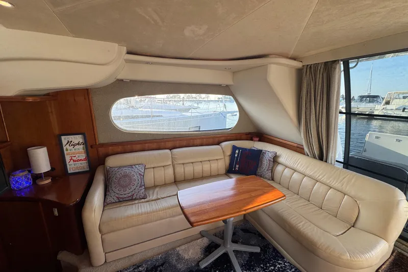 Slide: The Image of Interior of a 2003 Silverton 410 Sport Bridge yacht with leather seating and wooden table. - 48