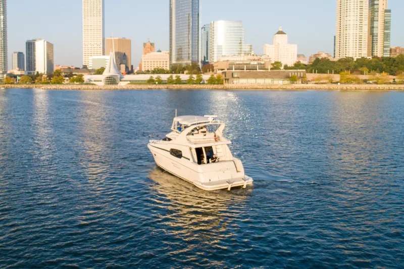 Slide: The Image of 2003 Silverton 410 Sport Bridge yacht cruising near city skyline on a sunny day. - 5