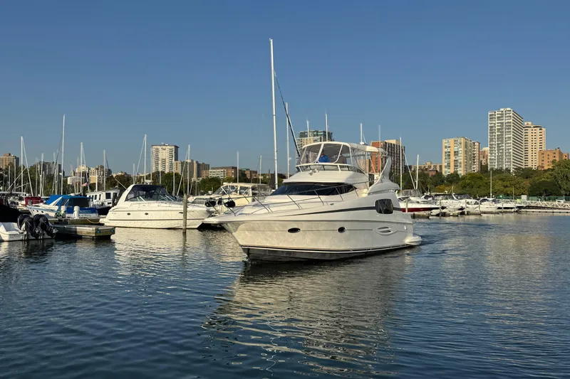Slide: The Image of 2003 Silverton 410 Sport Bridge yacht docked in urban marina with city skyline. - 53