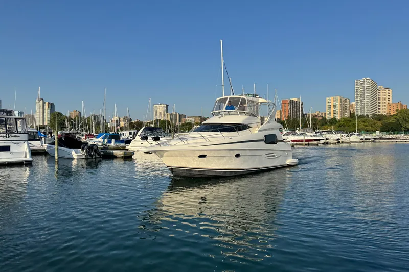 Slide: The Image of 2003 Silverton 410 Sport Bridge yacht docked in a marina with city skyline. - 54