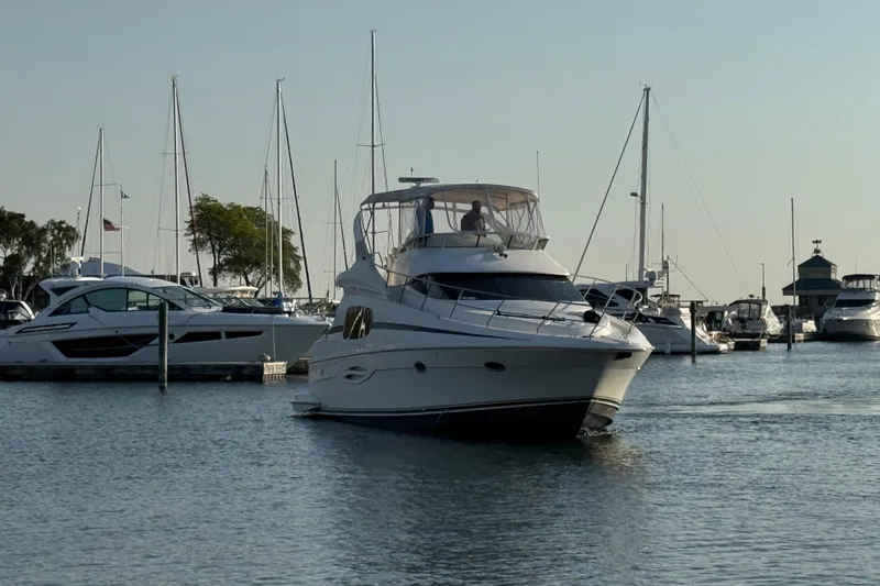 Slide: The Image of 2003 Silverton 410 Sport Bridge yacht docked in a marina with sailboats. - 62