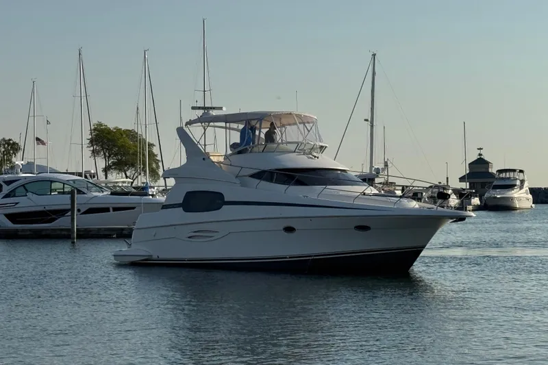 Slide: The Image of 2003 Silverton 410 Sport Bridge yacht docked in a marina with sailboats. - 63