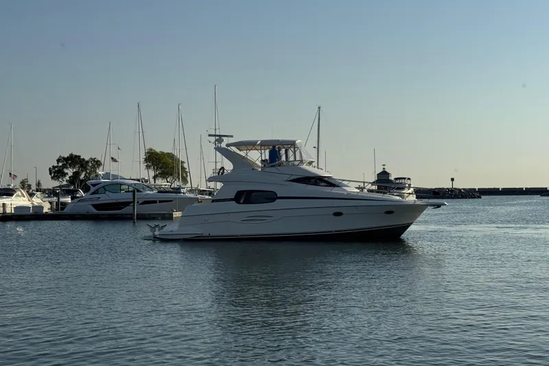 Slide: The Image of 2003 Silverton 410 Sport Bridge yacht docked in a marina with sailboats. - 64