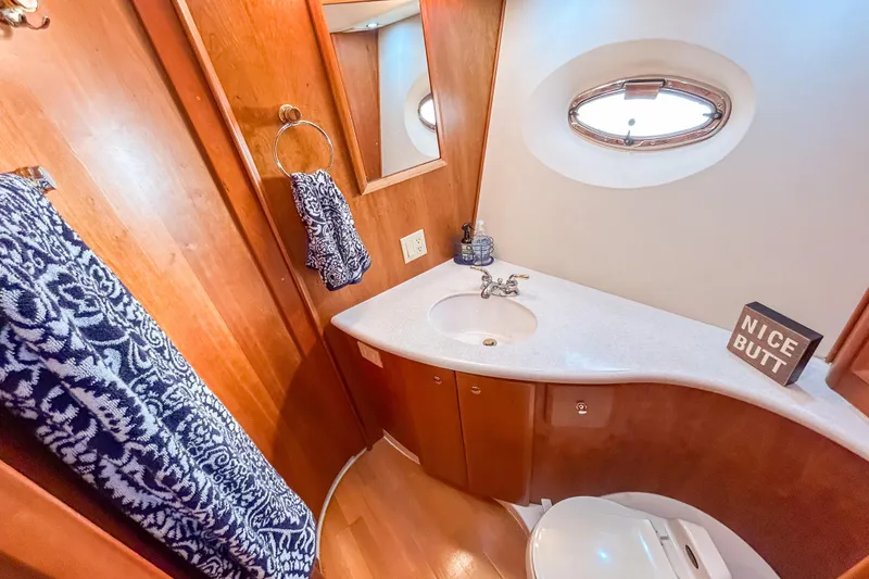 Slide: The Image of Luxurious 2003 Silverton 410 Sport Bridge bathroom with wood accents and nautical decor. - 73
