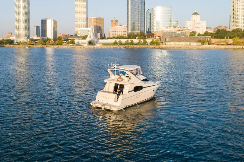 Slide: The Image of 2003 Silverton 410 Sport Bridge yacht cruising near city skyline on calm water. - 9
