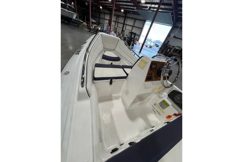 Slide: The Image of 2018 AB Inflatables Nautilus 12 DLX boat interior with steering wheel and seating. - 12