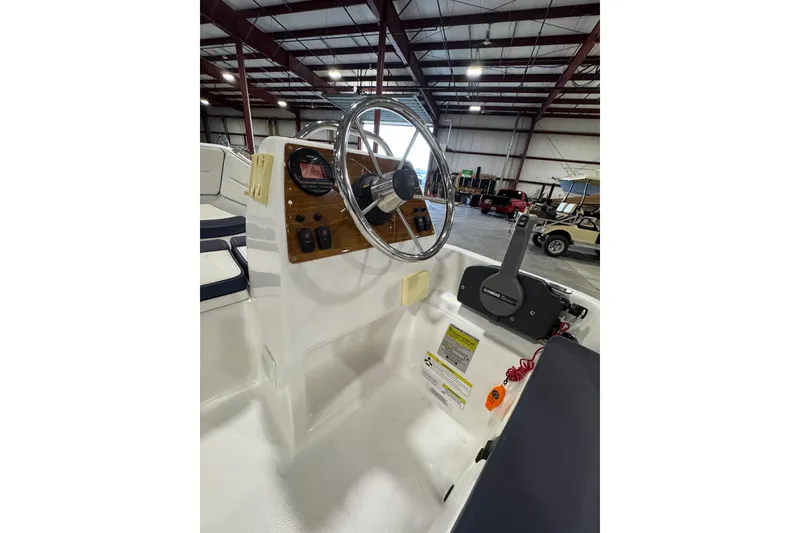 Slide: The Image of 2018 AB Inflatables Nautilus 12 DLX boat console with steering wheel and controls in a warehouse. - 13