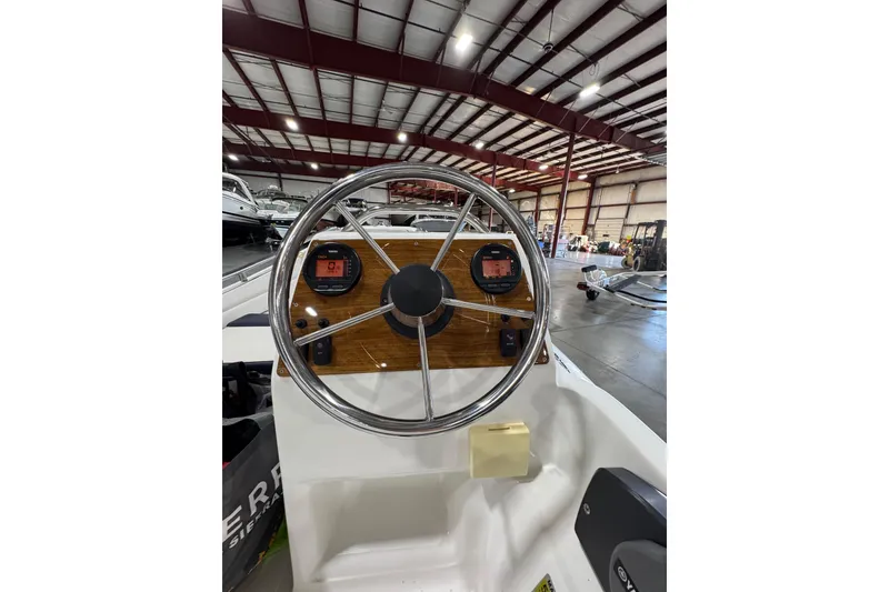 Slide: The Image of Steering wheel of 2018 AB Inflatables Nautilus 12 DLX boat in a warehouse setting. - 22