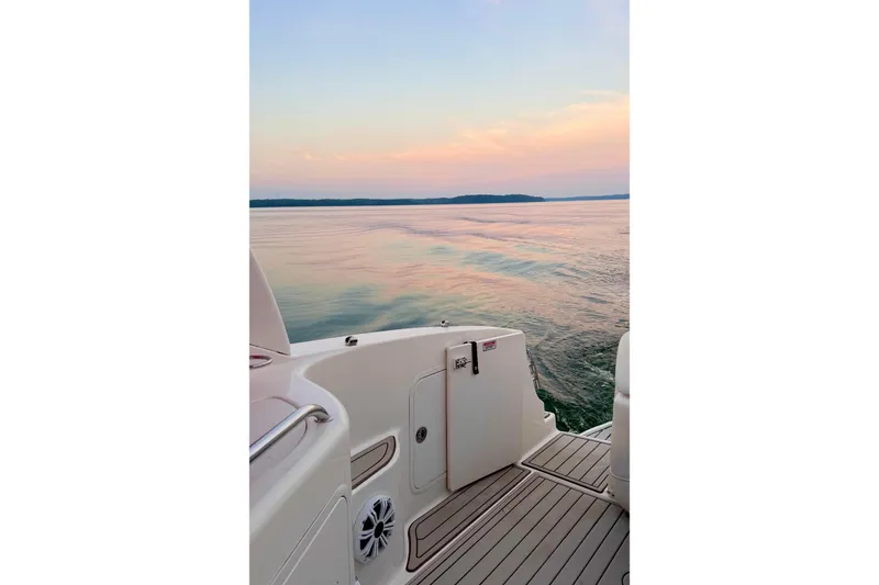 Slide: The Image of 2005 Sea Ray Sundancer 280 boat deck at sunset on calm waters. - 29