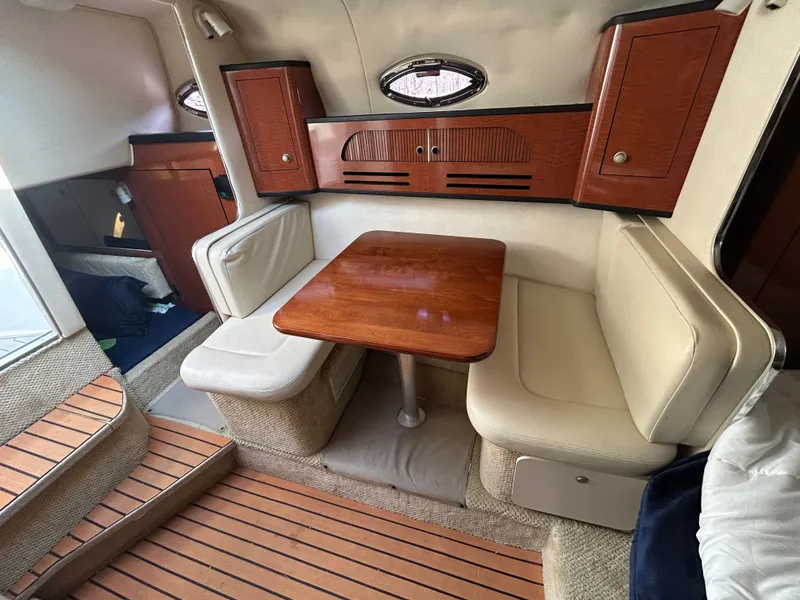 Slide: The Image of Interior of a 2005 Sea Ray Sundancer 280 with wooden table and seating area. - 9