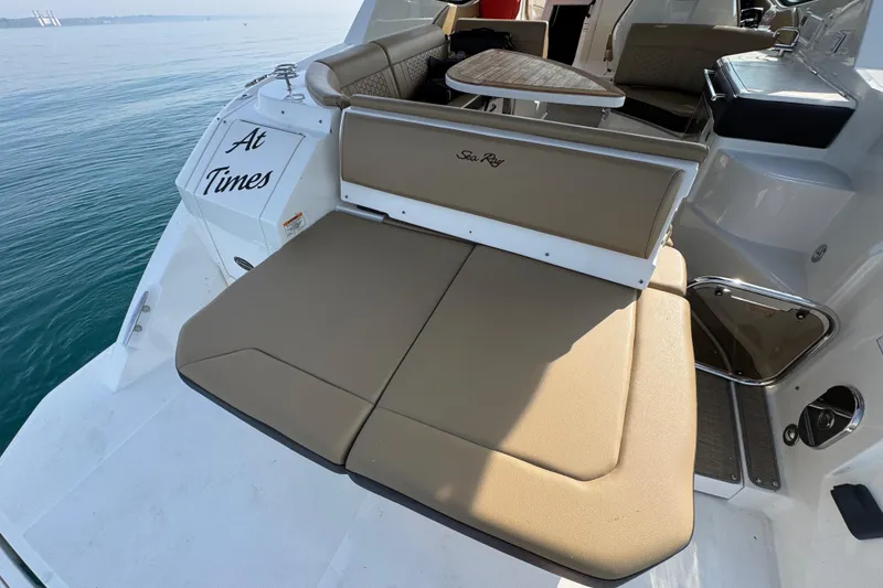 Slide: The Image of 2019 Sea Ray Sundancer 320 boat with tan seating and table on calm water. - 13