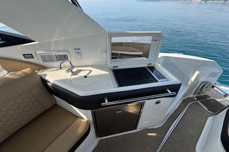 Slide: The Image of 2019 Sea Ray Sundancer 320 yacht interior with kitchenette and seating area. - 18
