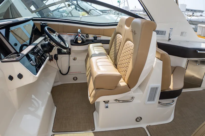 Slide: The Image of 2019 Sea Ray Sundancer 320 helm with dual tan seats and modern controls. - 22
