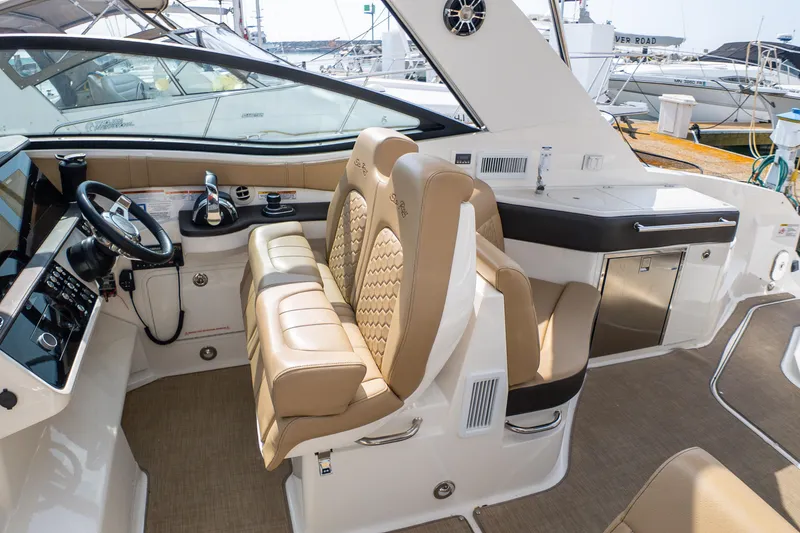 Slide: The Image of 2019 Sea Ray Sundancer 320 cockpit with luxurious seating and modern controls. - 23