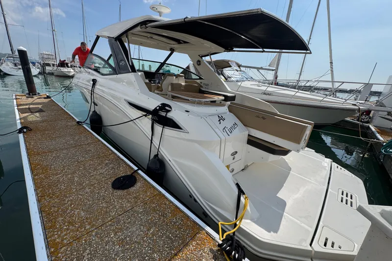 Slide: The Image of 2019 Sea Ray Sundancer 320 docked at marina, showcasing sleek design and spacious deck. - 3