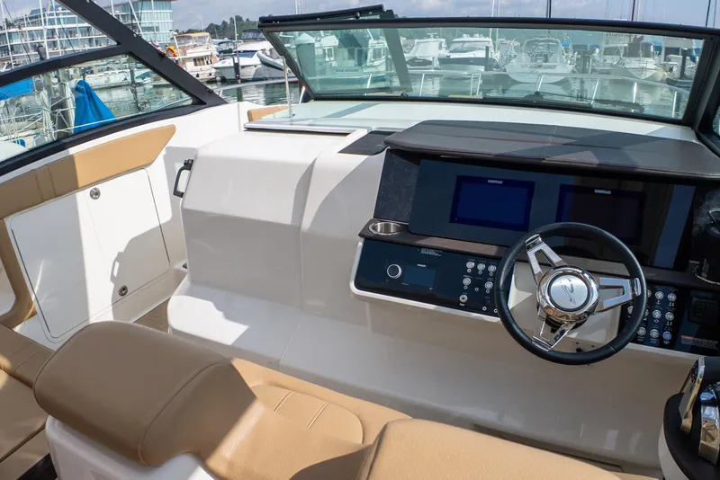 Slide: The Image of 2019 Sea Ray Sundancer 320 helm with modern controls and navigation screens at marina. - 30