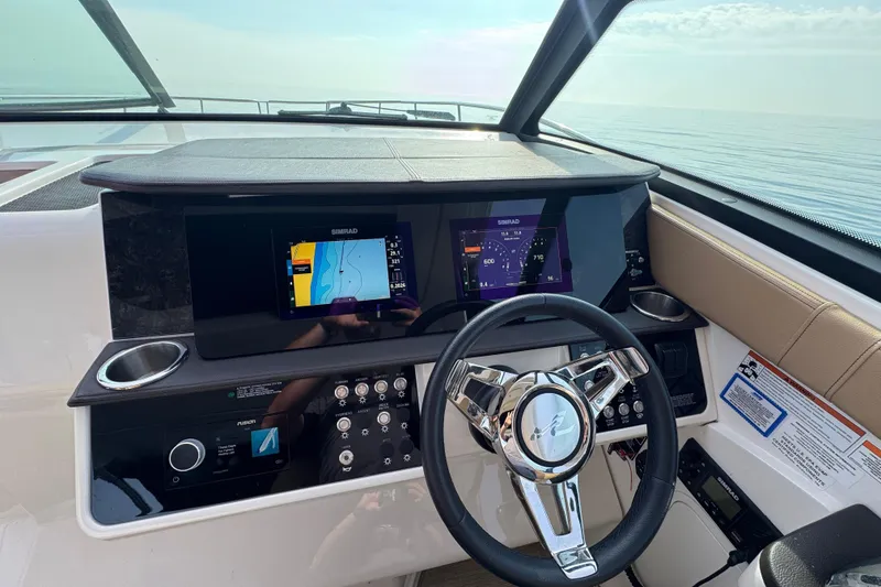 Slide: The Image of 2019 Sea Ray Sundancer 320 helm with Simrad navigation displays and steering wheel. - 32