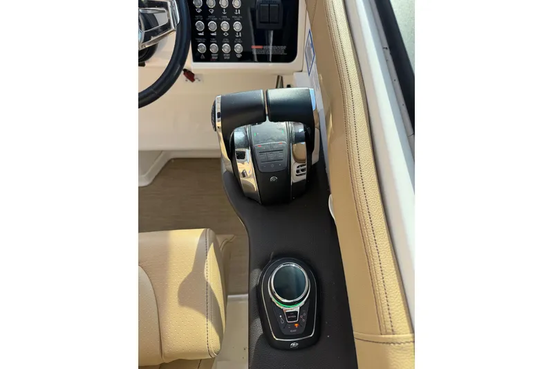 Slide: The Image of 2019 Sea Ray Sundancer 320 helm controls with joystick and throttle levers. - 33