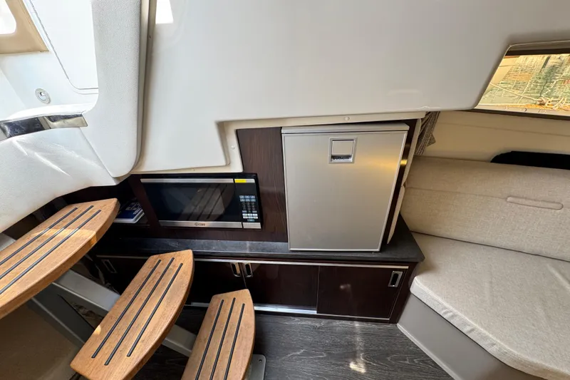 Slide: The Image of 2019 Sea Ray Sundancer 320 interior with microwave, fridge, and wooden steps. - 47