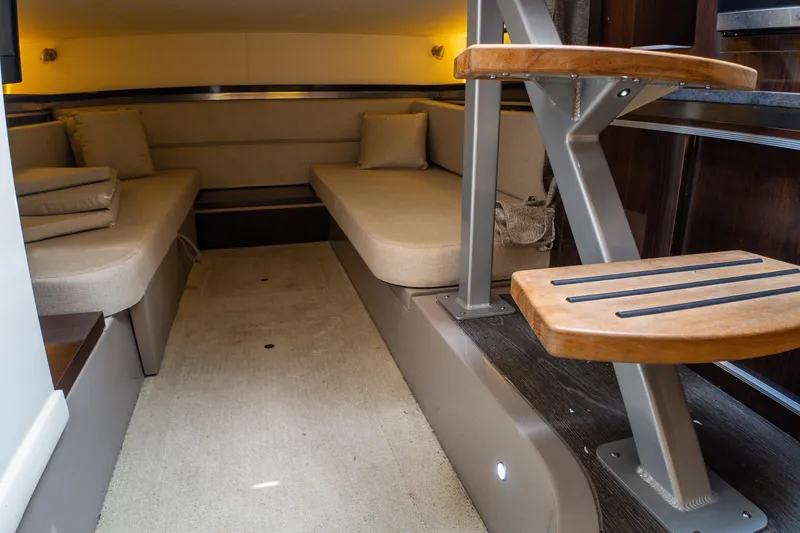 Slide: The Image of Interior cabin of 2019 Sea Ray Sundancer 320 with beige seating and wooden steps. - 48