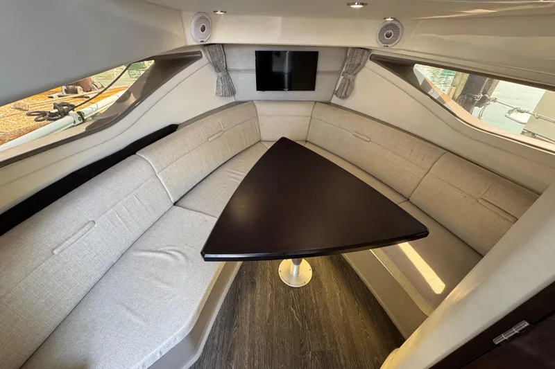 Slide: The Image of Interior of 2019 Sea Ray Sundancer 320, featuring a cozy seating area with a triangular table. - 50