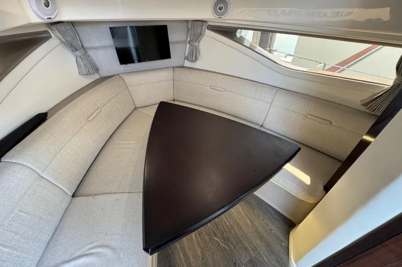 Slide: The Image of Interior of 2019 Sea Ray Sundancer 320 with beige seating and dark wood table. - 51